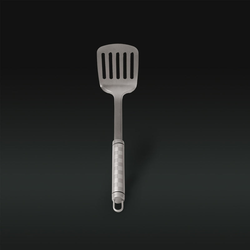 Metallic slotted spatula on a black background