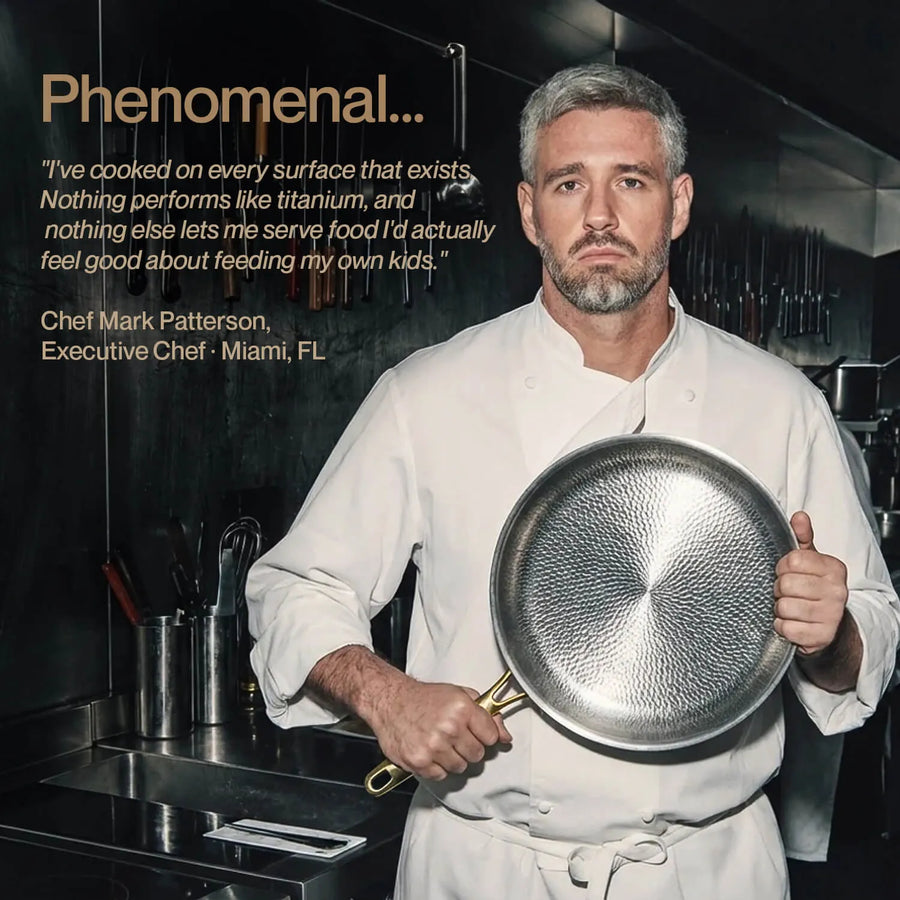 Chef Mark Patterson in a white chef coat holds a hammered stainless steel frying pan in a professional kitchen setting. Text on the left reads 'Phenomenal.