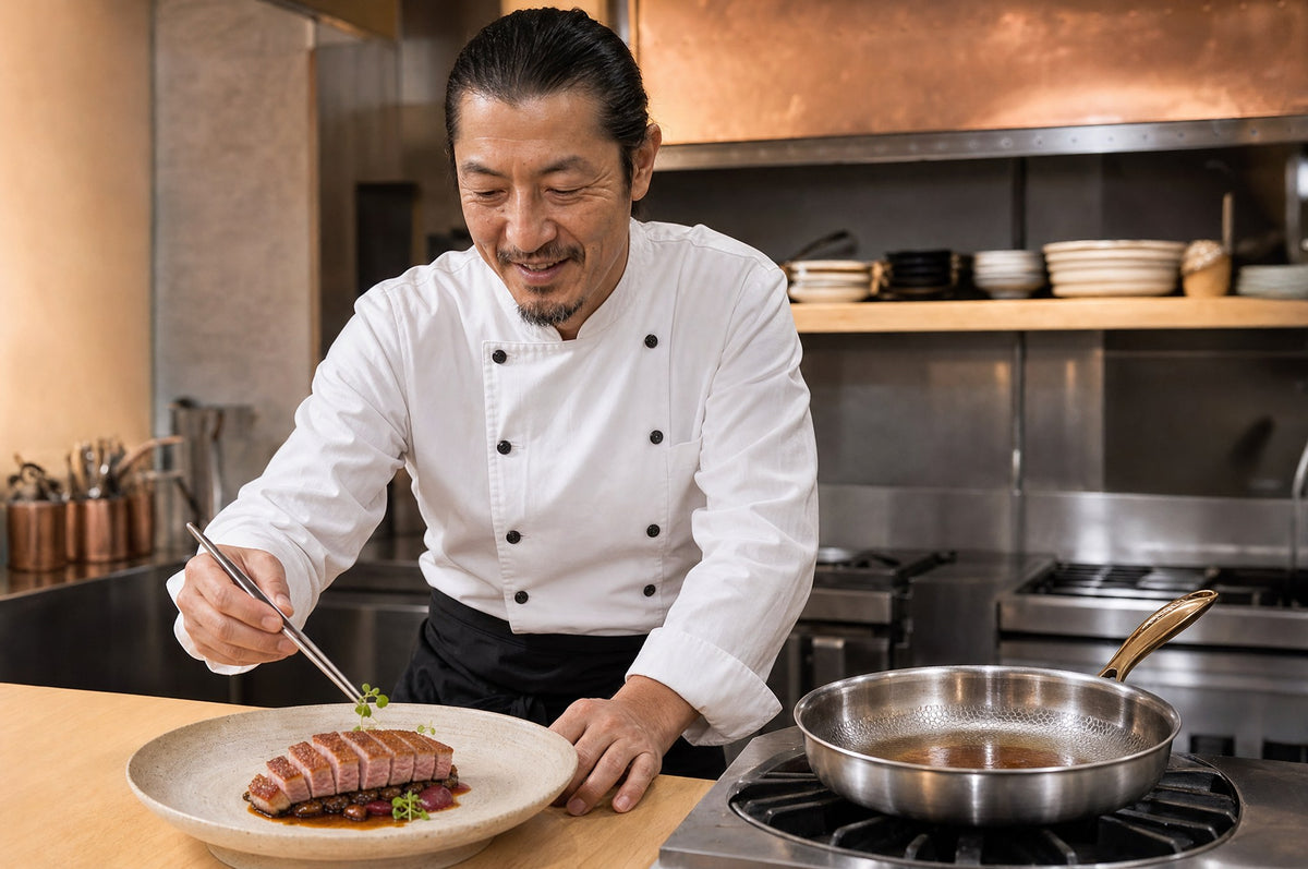 Chef plating seared duck beside the Taima pan