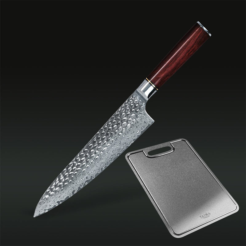 A kitchen knife with a hammered Damascus steel blade and a dark reddish-brown wooden handle, shown diagonally next to a rectangular metal cutting board on a dark gradient background.