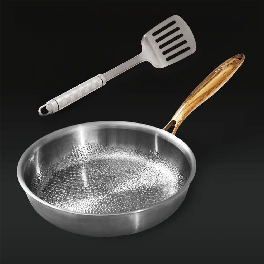 Silver frying pan with wooden handle and slotted spatula on a black background