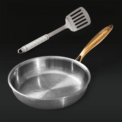Silver frying pan with wooden handle and slotted spatula on a black background